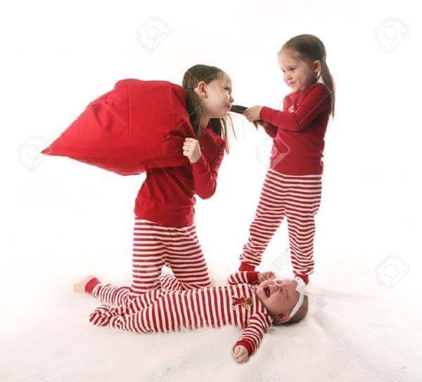 8383218-Three-sisters-dressed-in-Christmas-pajamas-Two-older-girls-are-pulling-hair-and-having-a-pillow-figh-Stock-Photo